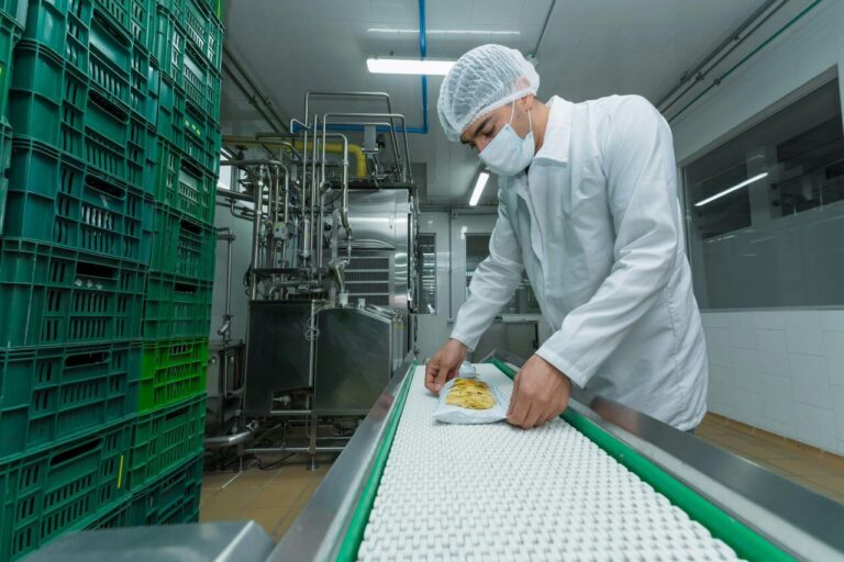 Pracownik przy taśmie produkcyjnej